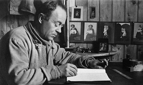 A challenging black and white jumpstart photo of a man journaling at a desk.