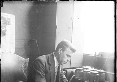 An expert man in a suit typing on a typewriter.