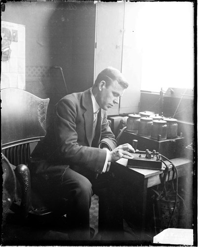 An expert man in a suit typing on a typewriter.