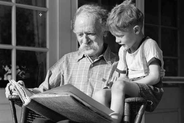 A grown man and a young boy appreciating a book.