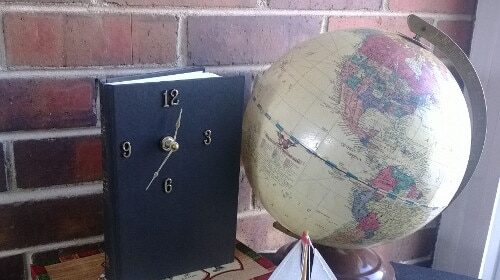 A clock next to a book
