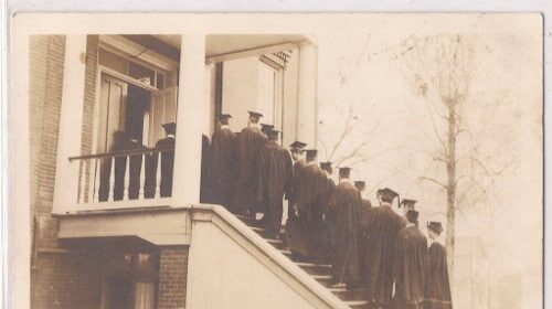 A group of graduates performing a ritual on the steps of a house, symbolizing personal change and the power within.