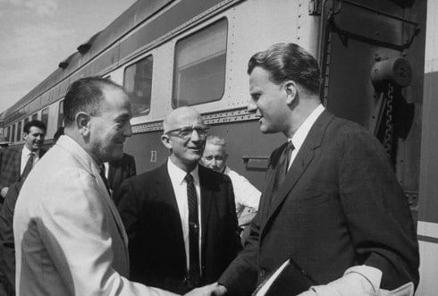 Vintage important businessmen shaking hands meeting outside train.