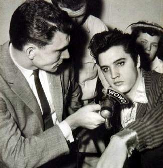 Elvis being interviewed by reporters.