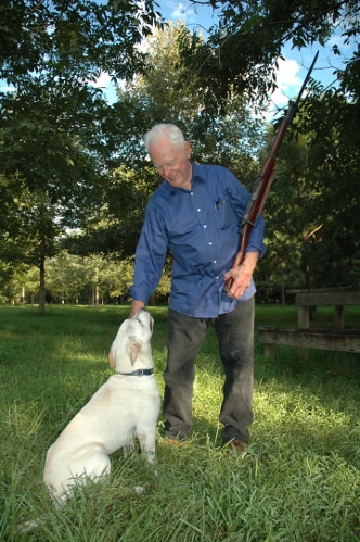 Vintage man holding gun in his left hand with a dog.