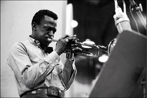 Miles Davis playing trumpet in studio.