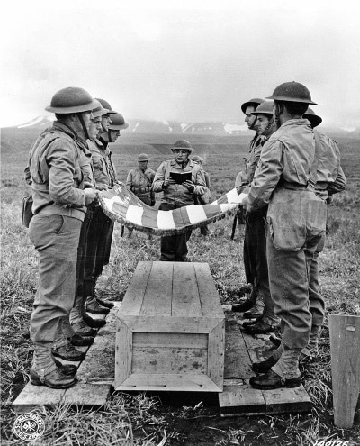 Vintage soldiers military funeral in field folding us american flag.