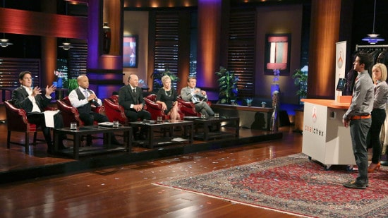 A group of people sitting in chairs on a Shark Tank stage.