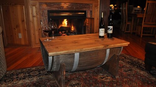 A whiskey barrel coffee table in front of a fireplace.