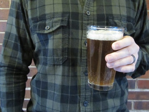 Man pouring beer into pint glass.