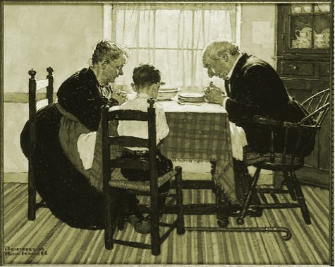 Vintage grandparents and grandson praying saying grace at dinner table.