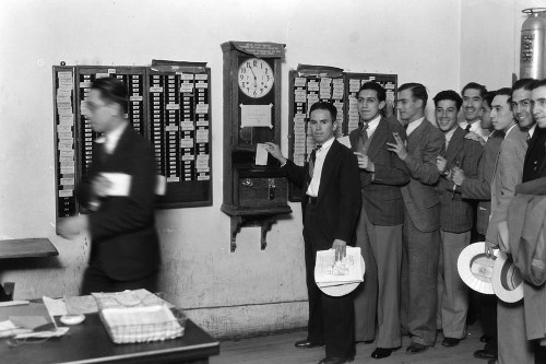 Vintage IBM office workings clocking in suits in line.