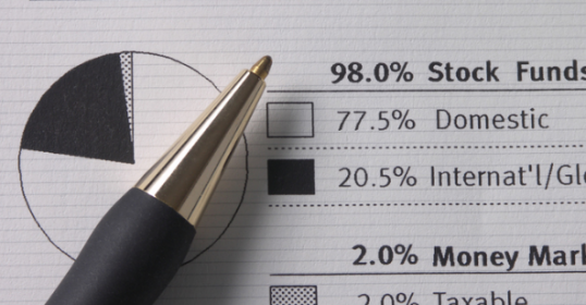 A pen rests on a sheet of paper featuring a pie chart, perfect for beginners in investing.