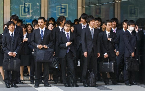 Vintage japanese students are standing and holding bags.