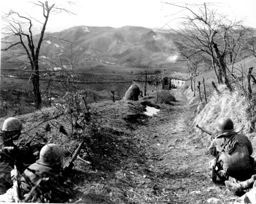 Vintage men military soldiers crouching trail on mountain with there guns.