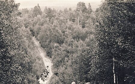 A group of people Ditch the Pavement as they walk down a dirt path.