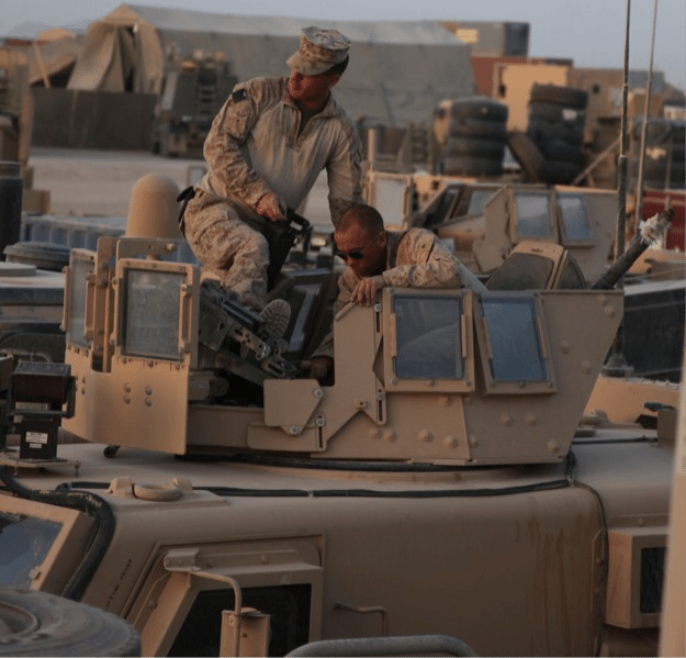 us marines checking machine guns on military trucks
