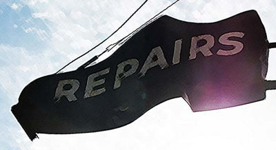 Shoe repair sign shaped like a shoe.