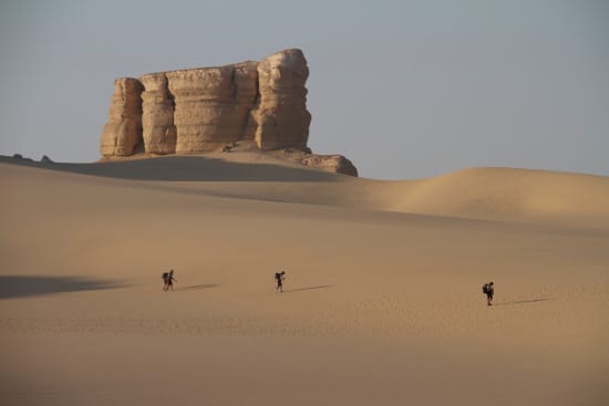 Desert ultra marathon three men running on sand.