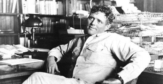 An old photo of a man sitting at a desk, exuding an air of Jack London-esque manliness.