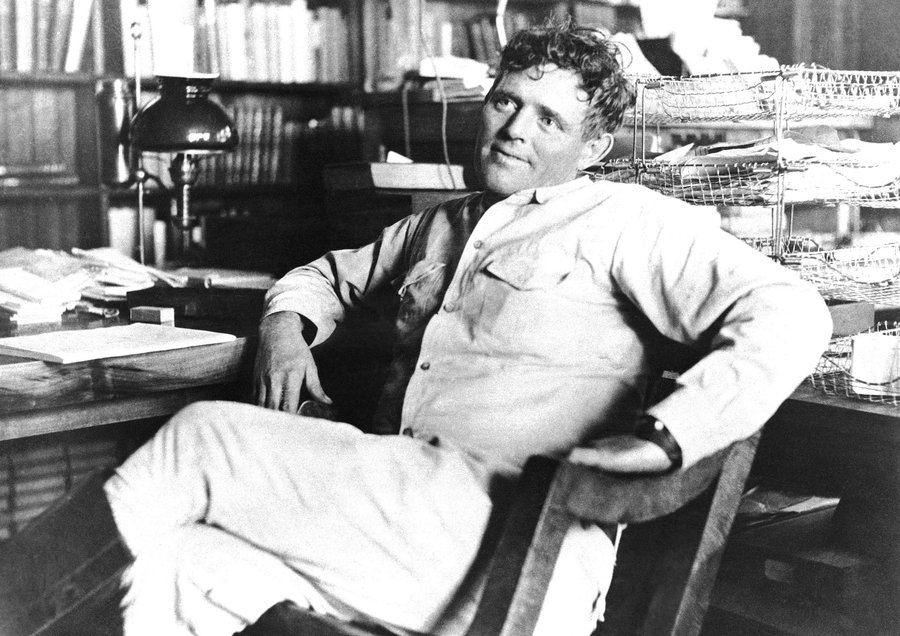 An old photo of a man sitting at a desk, exuding an air of Jack London-esque manliness.