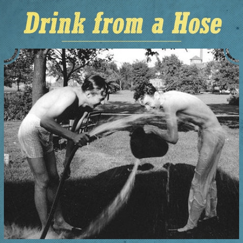 Vintage men drinking water from hose. 