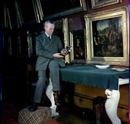 Vintage man in art gallery examining art.