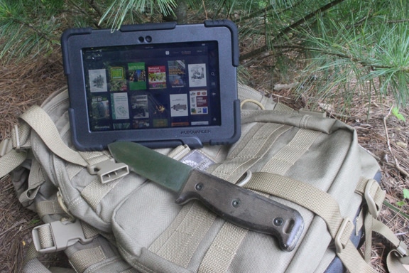 An iPad with a knife sits atop a backpack from the Digital Survival Library.
