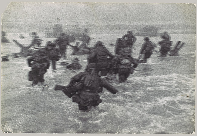A group of soldiers wading through the water on D-Day, a powerful remembrance of their bravery.