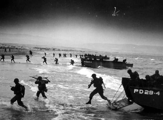 D-day Normandy invasion men running off ships storming beaches.