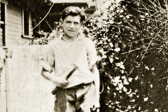  Louis Zamperini as young boy holding hammer in yard 