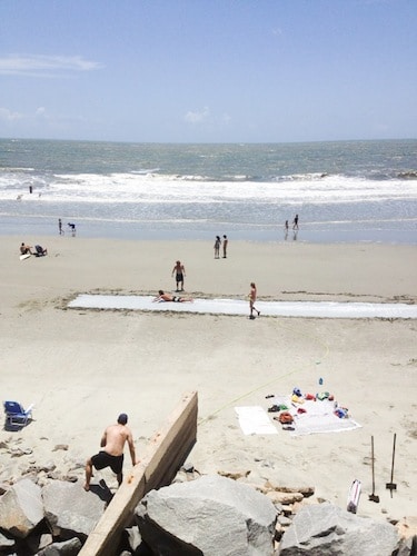 Adult sized mega slip n slide on beach.