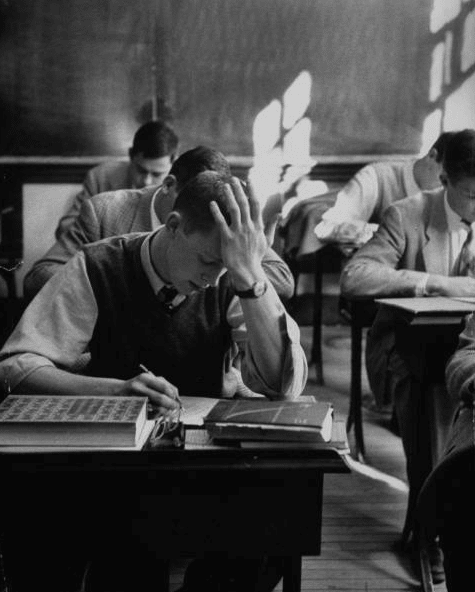 Vintage young man giving exam in classroom. 