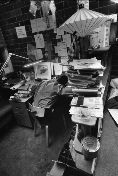 Vintage man head down on desk with bundle of papers.