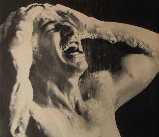 Vintage man use hands in shower suds. 