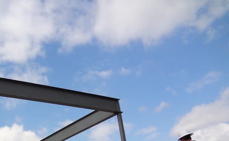Three architects standing in front of a steel structure.