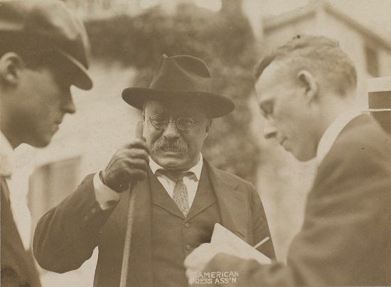 Teddy Theodore holding a stick with men.