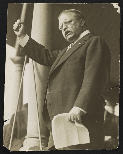 Teddy Theodore giving speech and raised his arm.