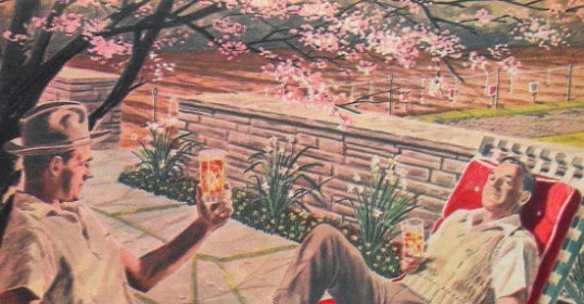 A man is chilling in a lounge chair, sipping on a bottle of whisky.