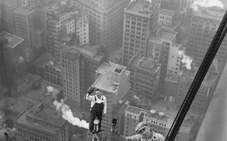 A black and white photo of laborers on a building.