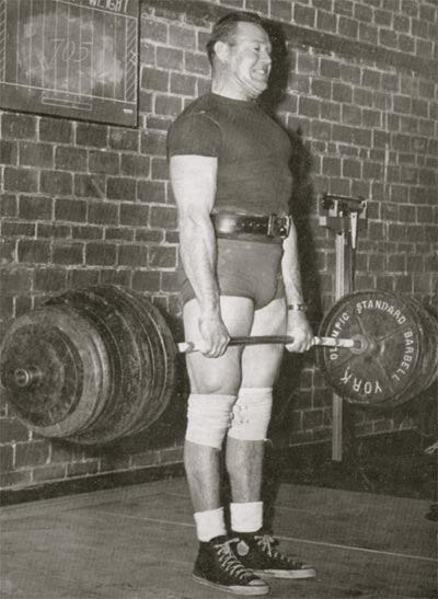 Vintage man lifting a heavy barbell. 