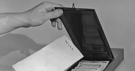 A person is protecting their legacy by opening a box with papers in it for estate planning.