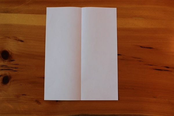 Paso 1: hoja de papel doblada por la mitad.