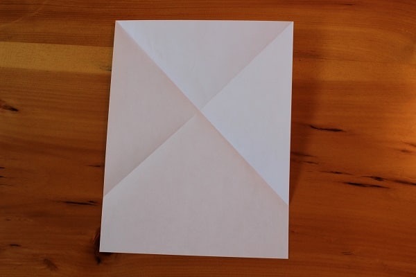 Hoja de papel desplegada con X pliegues.