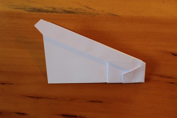 Fold airplane in half, outwards.