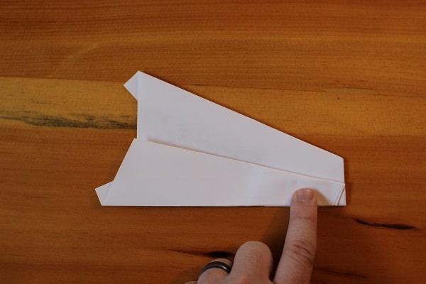 Fold wings down to meet bottom edge of the plane.