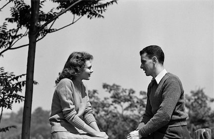 Monochrome photo of a man and woman perched on a fence, embodying the essence of clean communication.