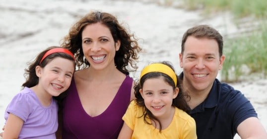 A happy family posing for a photo on the beach.