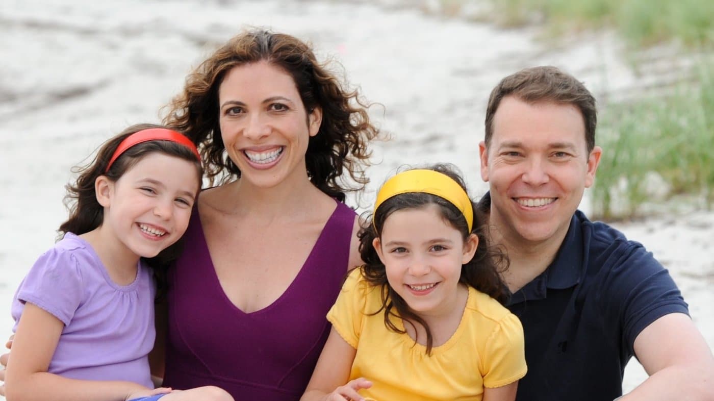 A happy family posing for a photo on the beach.