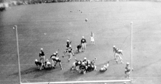 A black and white photo of men playing football.